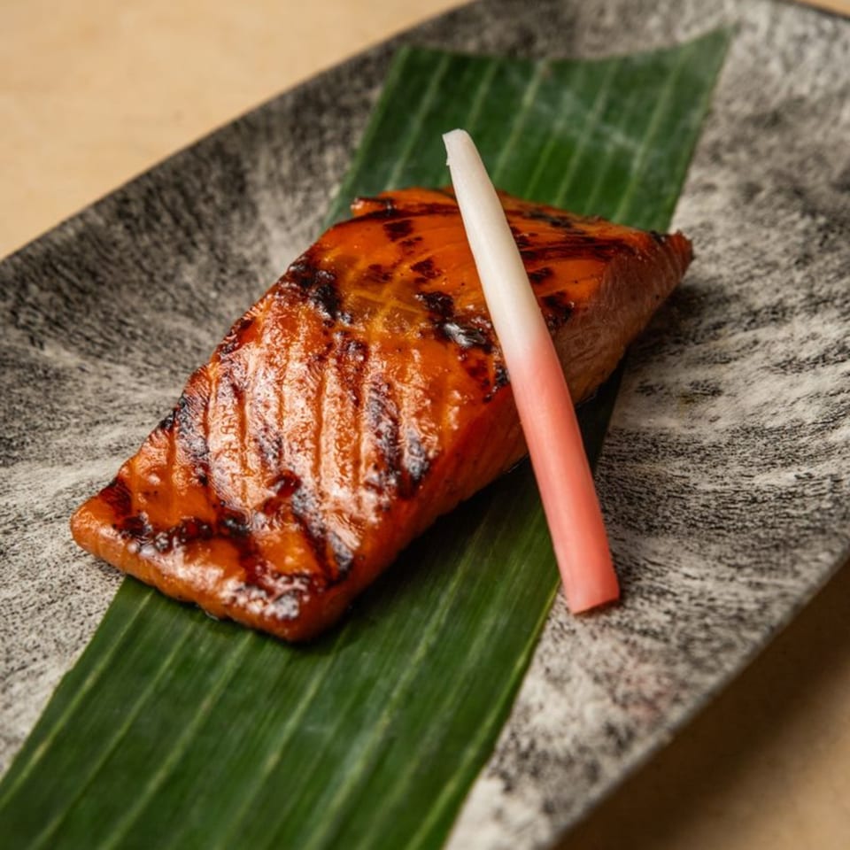 AquaSan's grilled salmon with a sweet glaze, served on a banana leaf with pickled ginger.